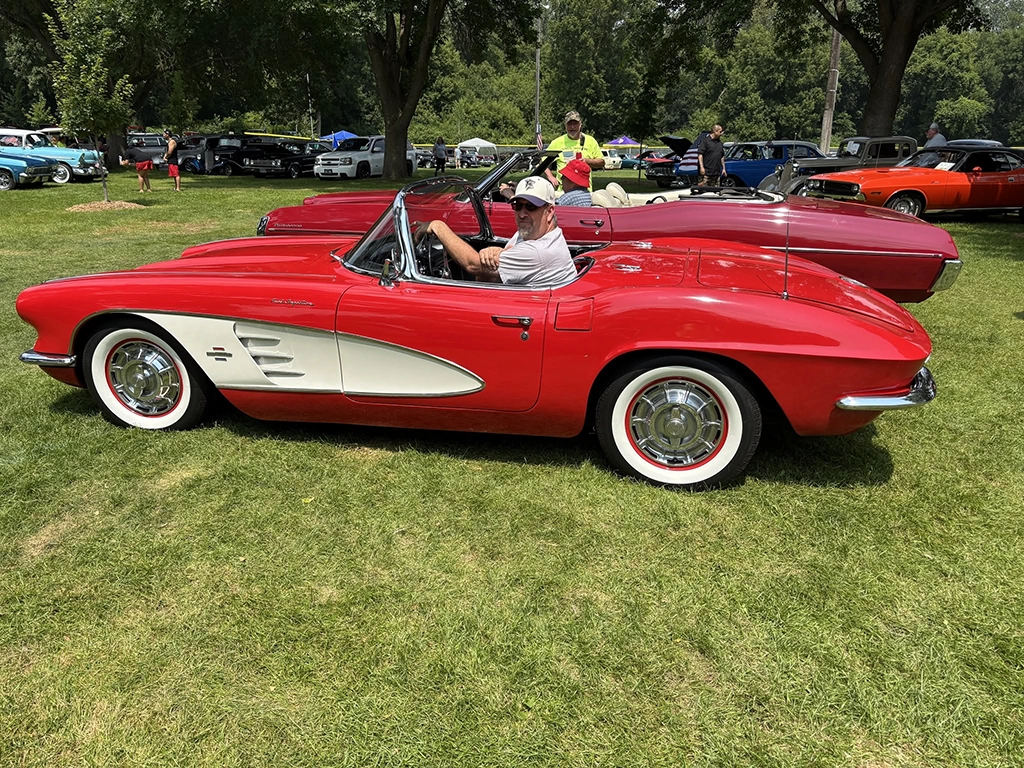 Classic red and white Corvette convertible on display among other collector cars at the Flags & Honor of Minnesota Car Show.